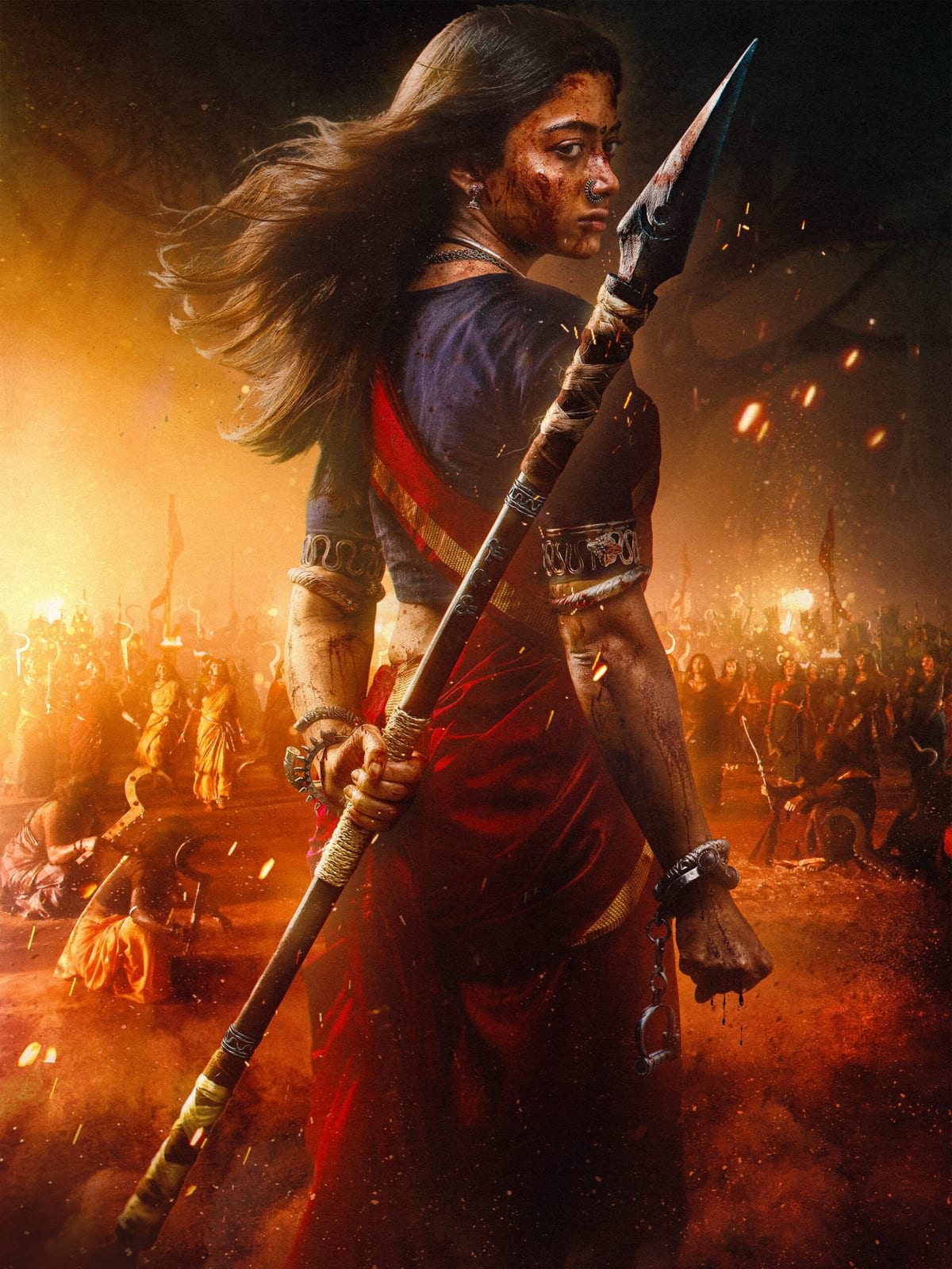 Rashmika Mandanna holds a spear amid fire and a crowd in promotional artwork for Mysaa.